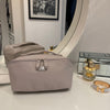 Mabel - Outlet makeup bag displayed on a vanity with a mirror, showcasing its elegant design and spacious compartments.