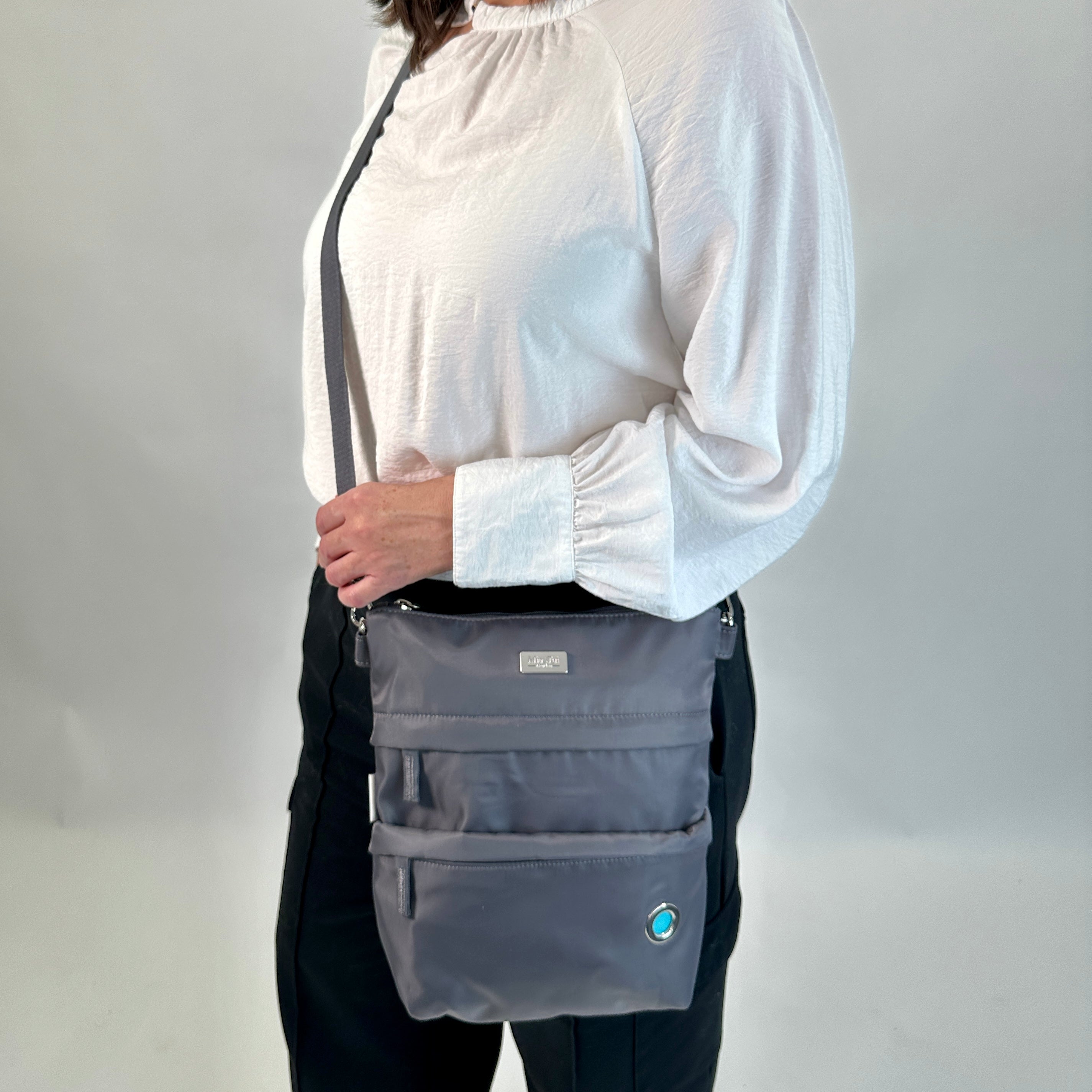 Person using O'Grady Dog Bag - Outlet, featuring water-resistant polyester and multiple compartments for dog walk essentials.