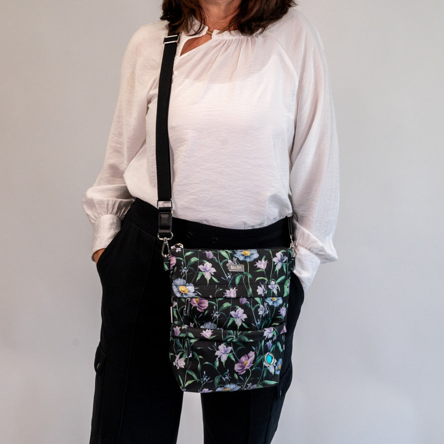 Woman wearing O'Grady Dog Bag - Outlet with floral design, showcasing water-resistant polyester and multiple compartments for dog walks.