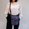 Woman wearing O'Grady Dog Bag - Outlet in blue floral print showcasing water-resistant polyester and multiple compartments.